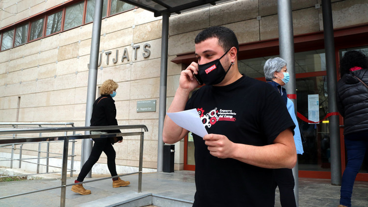 Pla mitjà del regidor de la CUP de Reus Edgar Fernández després de comparèixer als jutjats detingut pels Mossos, amb una acta a la mà. Imatge del 23 de febrer del 2021. Agència Catalana de Notícies