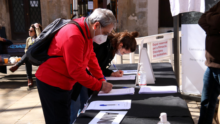 Dues persones signen a favor de la llei d'amnistia, en un acte d'Òmnium a Barcelona el 13 de març de 2021. Agència Catalana de Notícies