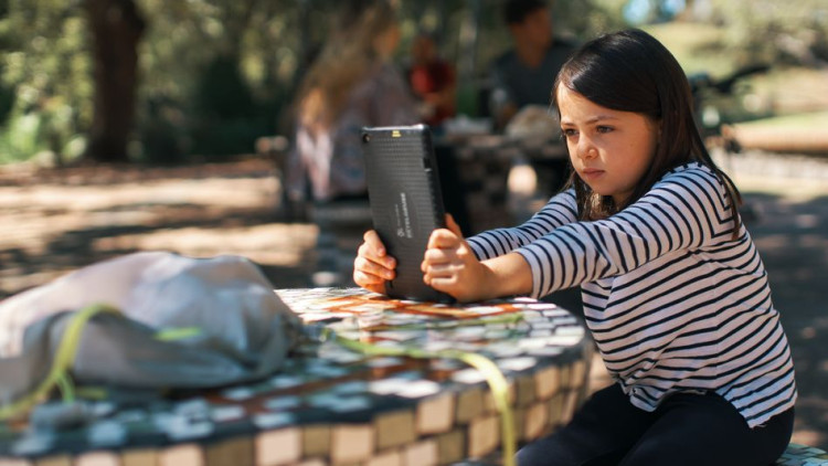 Amelia, estudiant de primària, de set anys, realitza les tasques escolars en un parc de Montevideo, utilitzant una tauleta que li va proporcionar el govern del seu país. Der Spiegel
