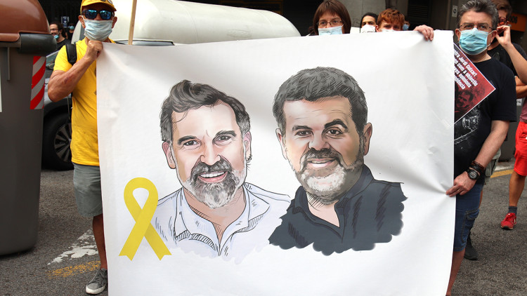 Pla curt d'una pancarta a l'acció convocada per Òmnium i l'ANC davant la delegació del govern espanyol a Barcelona coincidint amb els mil dies de presó de Jordi Cuixart i Jordi Sànchez, el 12 de juliol del 2020. Agència Catalana de Notícies