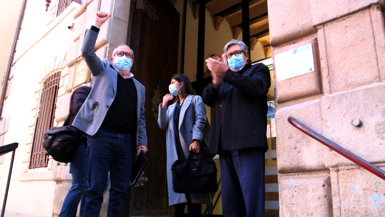 Pla contrapicat de l'alcalde de Roquetes, Paco Gas, amb el puny aixecat abans d'entrar al jutjat penal de Tortosa, acompanyat per l'advocat i portaveu municipal d'ERC a Tortosa, Xavier Faura. Imatge del 12 d'abril del 2021. Agència Catalana de Notícies
