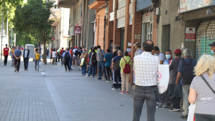 Persones necessitades fan cua per rebre aliments