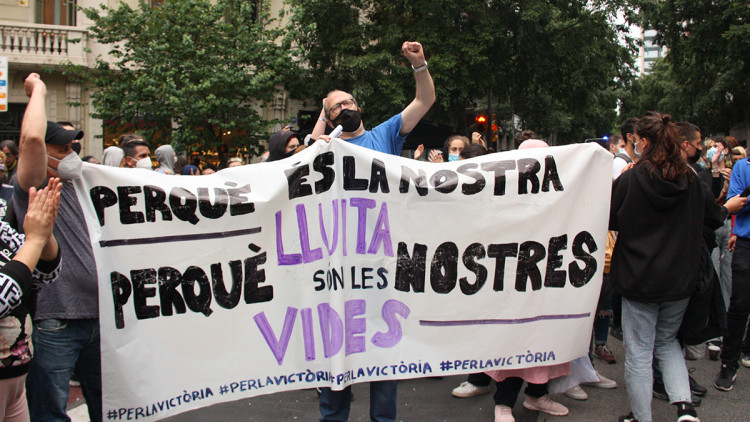Pla general d'un dels manifestants que ha ocupat la seu d'Esquerra Republicana en protesta per un desnonament al Bloc Llavors del Poble Sec sostenint una pancarta. Imatge del 25 de maig de 2021. Agència Catalana de Notícies