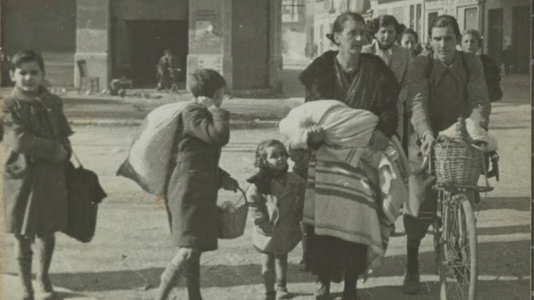 Família a la Gran Via Jaume I de Girona, tornant del refugi després d’un bombardeig, també imatge de la coberta del llibre de Quim Nadal. Ajuntament de Girona, CRDI (Campúa). Joan Bosch Rossell