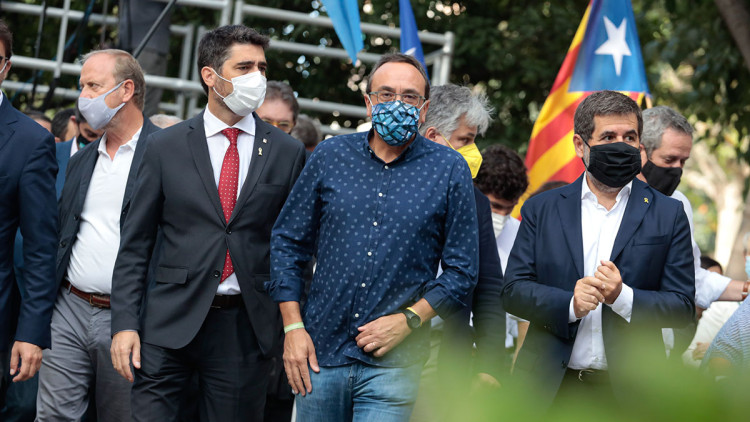 Jordi Puigneró, Josep Rull i Jordi Sànchez caminen davant d'una estelada, l'11 de setembre del 2021. Agència Catalana de Notícies