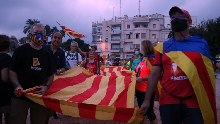 Pla general d’uns participants de la Marxa Centre subjectant una estelada gegant en la seva arribada a Sant Carles de la Ràpita. Agència Catalana de Notícies