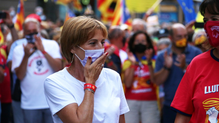 Primer pla de Carme Forcadell, emocionada i llençant petons als manifestants davant la capçalera de la manifestació de la Diada, amb milers de persones al darrere, baixant per Via Laietana. Imatge de l'11 de setembre de 2021. Agència Catalana de Notícies