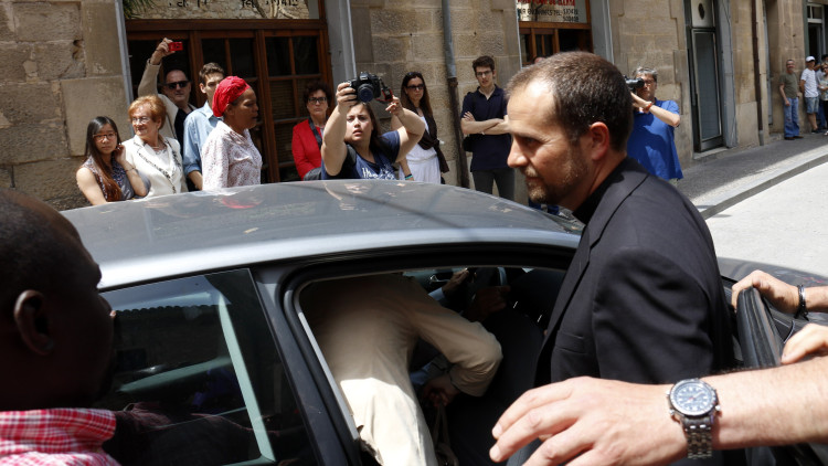 Pla mig on es pot veure el bisbe de Solsona, Xavier Novell, entrant en un cotxe a la sortida de l'església de Tàrrega on ha rebut una escridassada per les seves declaracions sobre els homosexuals, el 28 de maig de 2017. Agència Catalana de Notícies