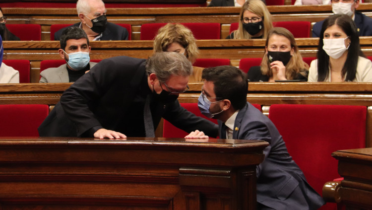 Pla obert del conseller d'Economia, Jaume Giró, parlant amb el president del Govern, Pere Aragonès, durant el ple del Parlament. Agència Catalana de Notícies