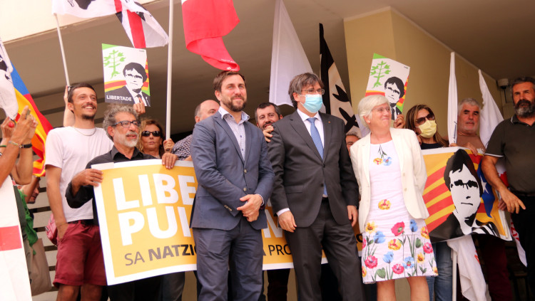 Puigdemont, Comín i Ponsatí a la sortida del tribunal de Sàsser i davant una pancarta de suport, el 4 d'octubre del 2021. Agència Catalana de Notícies