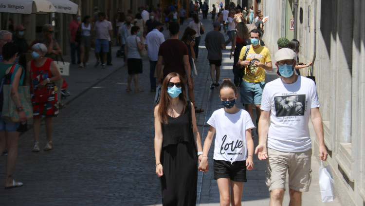 Pla mitjà d'una família caminant tots amb mascareta aquest dissabte 26 de juny de 2021 a Girona. Agència Catalana de Notícies