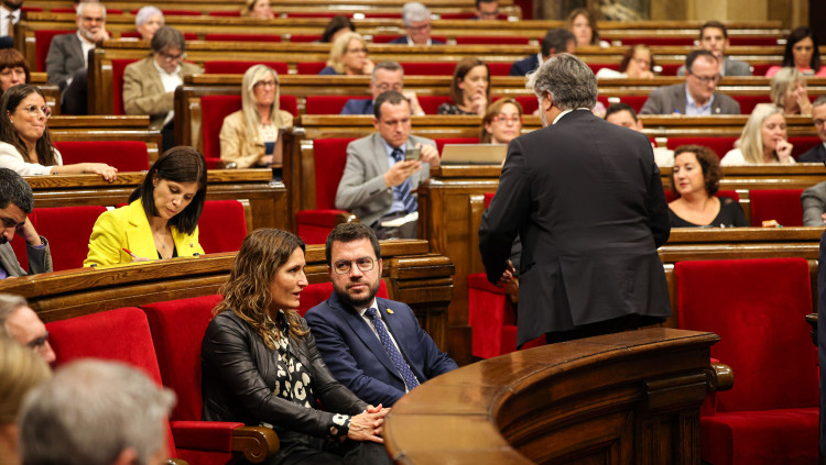 El president de Junts, Albert Batet, d'esquenes, torna al seu escó amb el president de la Generalitat, Pere Aragonès, assegut.. Agència Catalana de Notícies