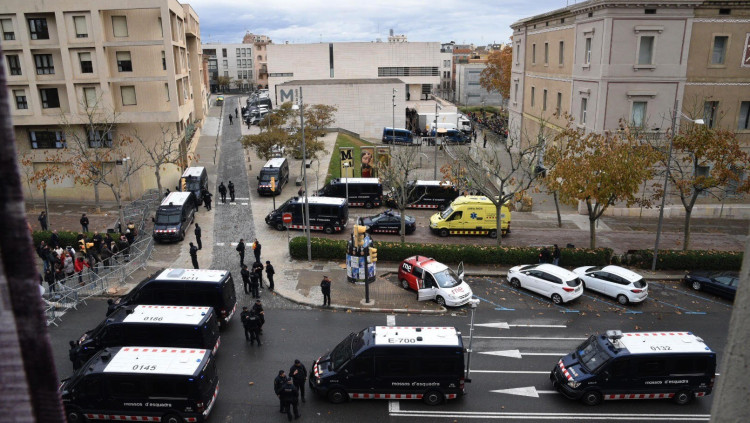 El Museu de Lleida, al centre, al fons. A la dreta, la furgoneta que carrega les obres. En primer terme, el cordó policial dels Mossos. EFE
