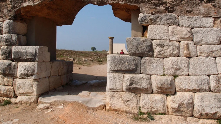 Porta de la ciutat romana d'Empúries amb un penis tallat en el mur.