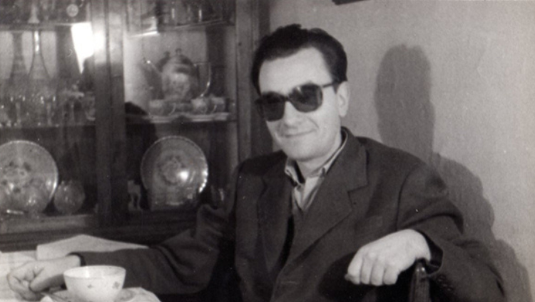 Joan Brossa jove assegut a la taula de casa al carrer de Muntaner, 1960. Arxiu MACBA, CC BY-SA 2.0, via Wikimedia Commons