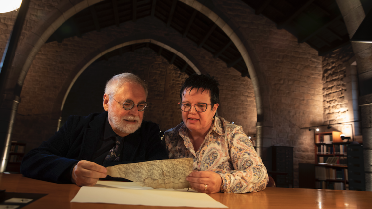 Jesús Alturo i Tània Alaix a la Biblioteca de Catalunya, amb un document escrit en llatí pel prevere Traver Radolf, el mateix autor de la primera còpia catalana del Llibre dels Jutges.. JORDI PLAY