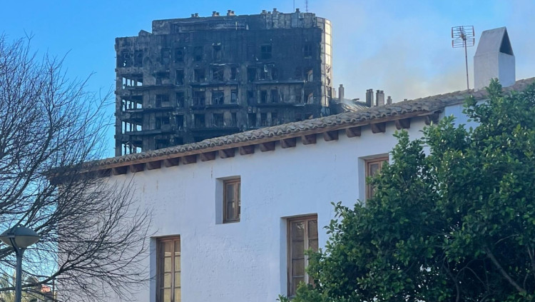 L’alqueria de Ricós, una de les poques que va sobreviure a Campanar, i darrere, l’edifici sinistrat.