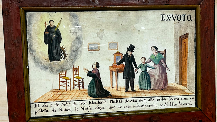Exvot d’un devot de sant Muç. El text diu: «El dia 3 de setembre de 1860 Eleuterio Tlullás de edat 2 añs es ba beura una empolleta de Rabel, lo Metje digué que se cremaria el ventra. Y Sant Mus la curà.»