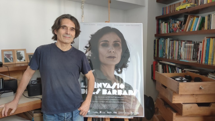 El director Vicent Monsonís posa davant el cartell de la seua pel·lícula.
