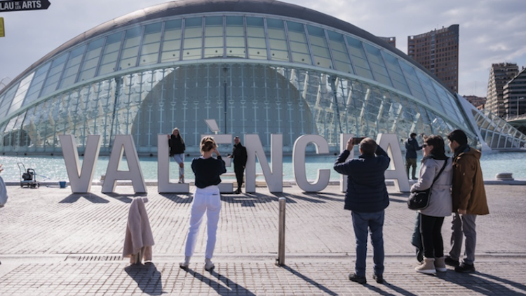 Un grup de turistes es fotografien, a la Ciutat de les Arts i les Ciències, davant les lletres que conformen la ciutat de València.. Europa Press