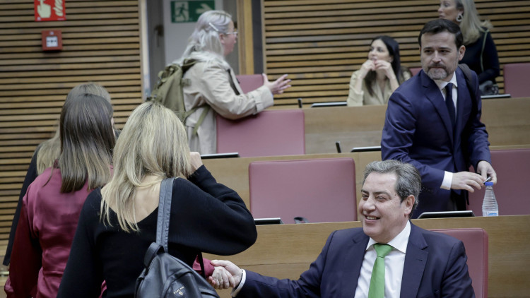 El síndic parlamentari de Vox, José María Llanos, saluda algunes companyes del seu grup parlamentari en un ple de Les Corts.. José Cuéllar / Corts Valencianes