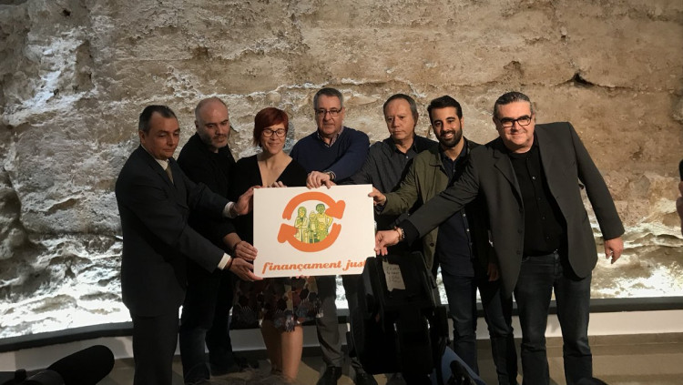 Els representants de la Comissió per un Finançament Just amb la nova imatge dissenyada per Paco Roca| EL TEMPS