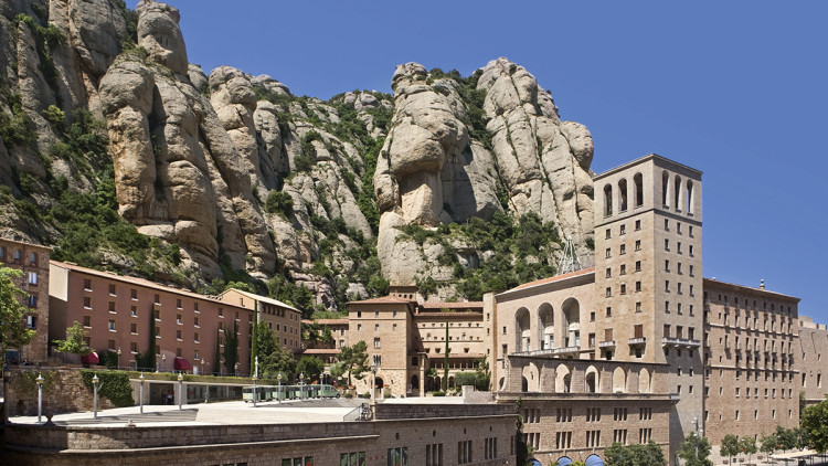 Montserrat. L’accidentat relleu de la muntanya de Montserrat fa que el santuari presenti una construcció irregular. El seu conjunt arquitectònic i urbanístic està integrat per dos grans grups d’edificis: la basílica, amb les dependències monàstiques, i les construccions destinades als visitants i pelegrins.. Diputació de Barcelona