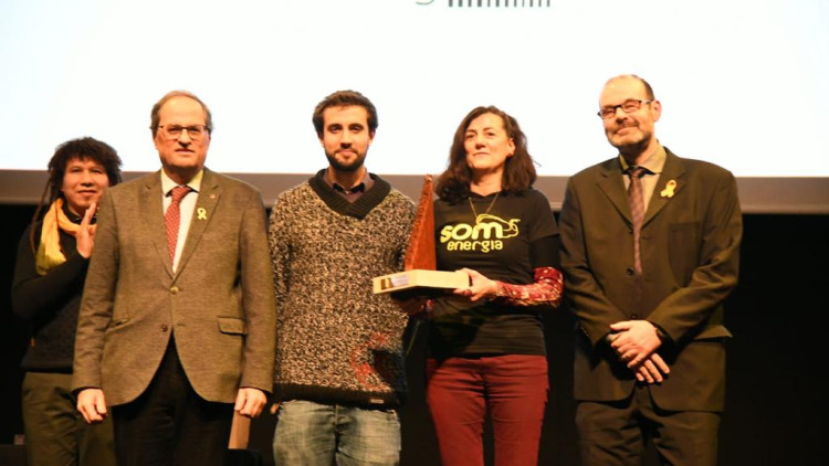 Membres de Som Energia posen amb el premi al costat de Quim Torra i del president de Plataforma per la Llengua, Òscar Escuder. Plataforma per la Llengua