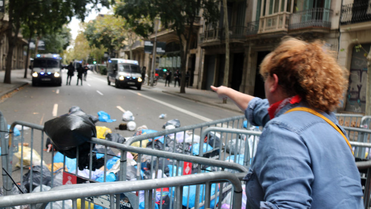 Una manifestant llança escombraires al costat de la delegació del govern espanyol a Barcelona. Agència Catalana de Notícies