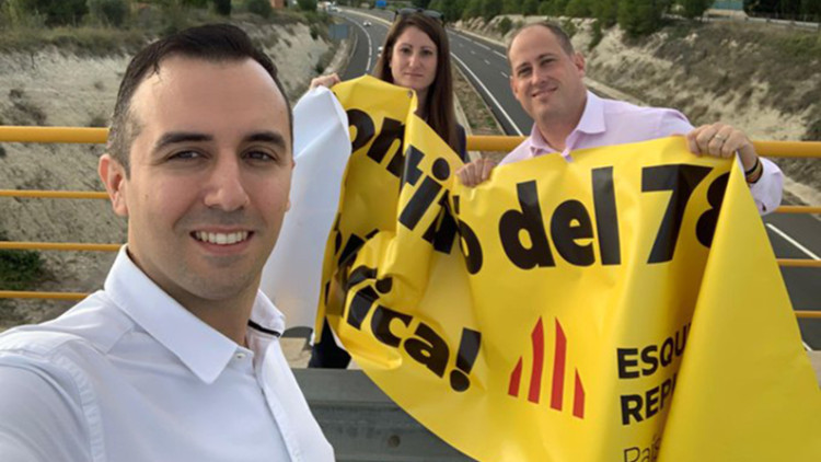Miguel Pascual, en primer terme, i Ana Vega i David García Gomis, darrere, després de retirar una pancarta d'ERPV a l'autovia central, a ltura d'Ontinyent.