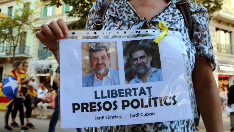 Una manifestant mostra imatges de Jordi Sànchez i Jordi Cuixart el 2017. Agència Catalana de Notícies