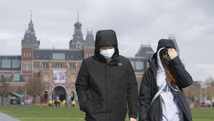 Dues persones protegides amb mascareta passegen per Amsterdam. Europa Press