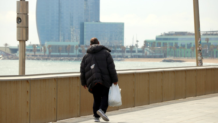 Un home passeja per la Barceloneta buida per les restriccions. Agència Catalana de Notícies