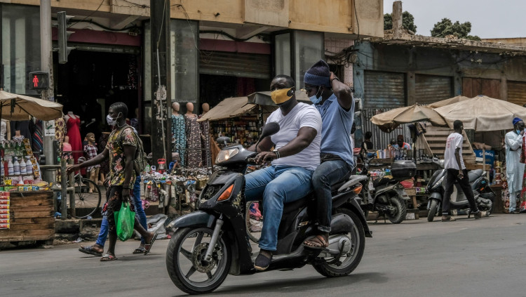 Dos homes amb mascareta viatgen en moto per Dakar, Senegal. Europa Press