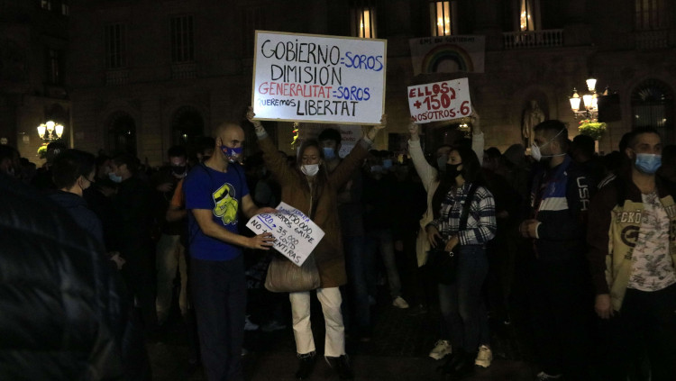 Un grup de persones mostra pancartes durant una concentració contra les restriccions per frenar la covid-19. Agència Catalana de Notícies