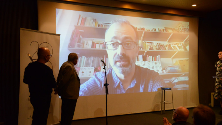 Ferran Joanmiquel, premi Pere Capellà de Teatre, s'adreça al públic per vídeo. Prats i Camps