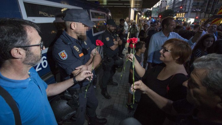 Representants d'Acció Cultural del País Valencià ofereixen clavells a la policia espanyola | ACPV